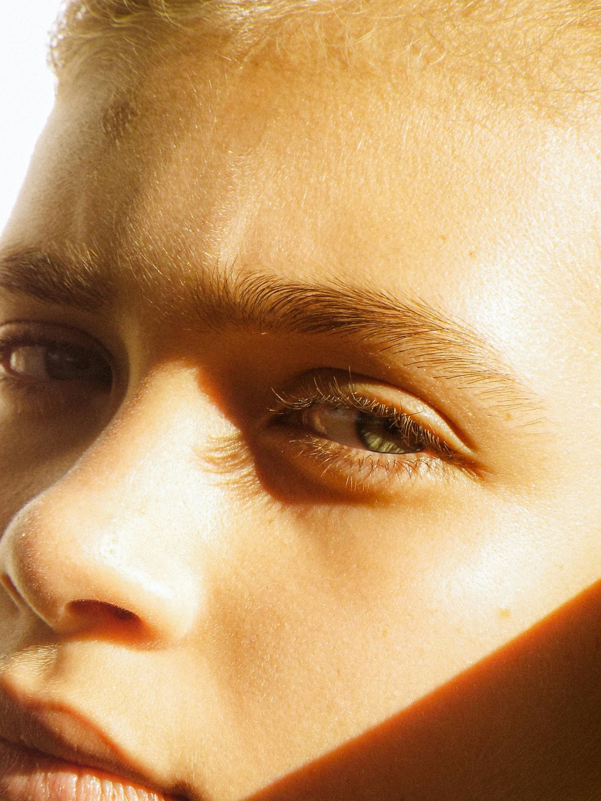 Persons with short blonde hare with bright sunlight casting shadows on their face